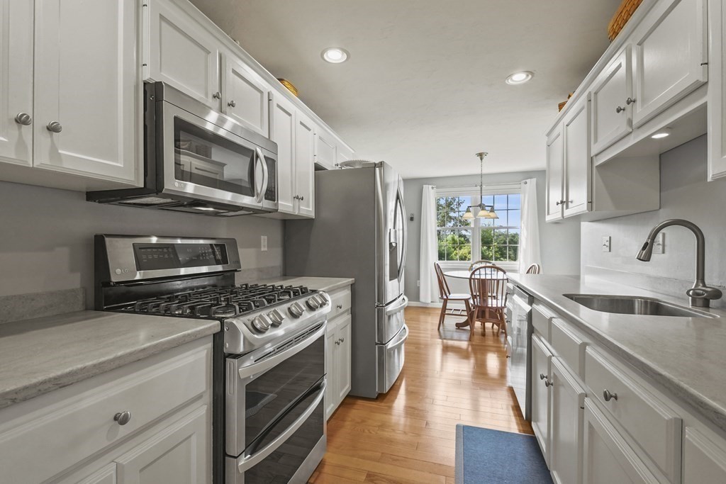 148 Ariel Circle, Unit 148 Sutton, MA 01590 - Photo 14 of 35 a kitchen with stainless steel appliances a stove sink microwave and cabinets
