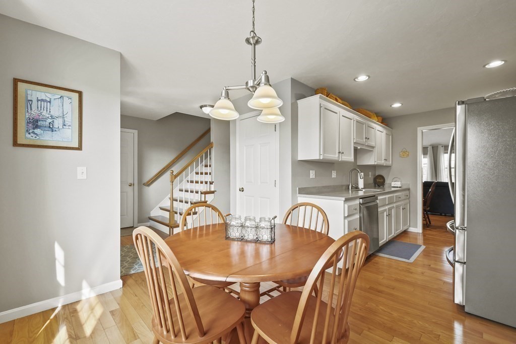 148 Ariel Circle, Unit 148 Sutton, MA 01590 - Photo 16 of 35 a dining room with furniture a chandelier and wooden floor