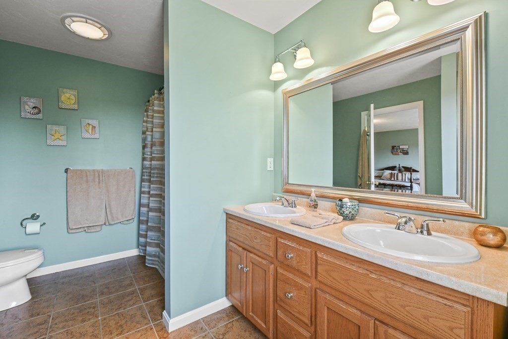 148 Ariel Circle, Unit 148 Sutton, MA 01590 - Photo 26 of 35 a bathroom with a granite countertop sink a toilet and a mirror