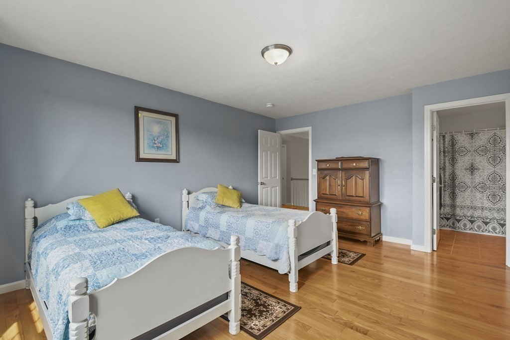 148 Ariel Circle, Unit 148 Sutton, MA 01590 - Photo 28 of 35 a bedroom with two beds and wooden floor