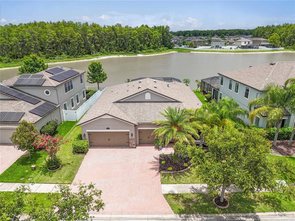 an aerial view of a house with a garden and lake view