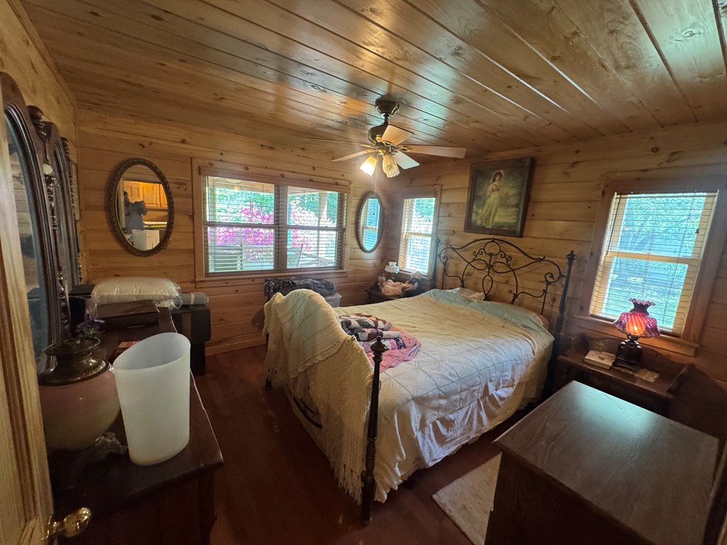 33 Big Tree Road Suches, GA 30572 - Photo 18 of 25 a bedroom with a bed a chandelier and dresser