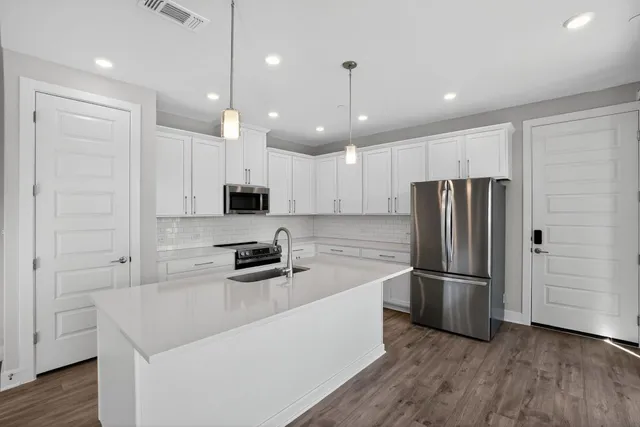 a kitchen with stainless steel appliances a refrigerator sink and microwave