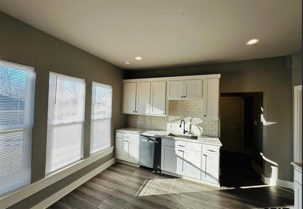 1408 East Houston Street Tyler, TX 75702 - Photo 5 of 15 a kitchen with a sink cabinets stainless steel appliances and a window