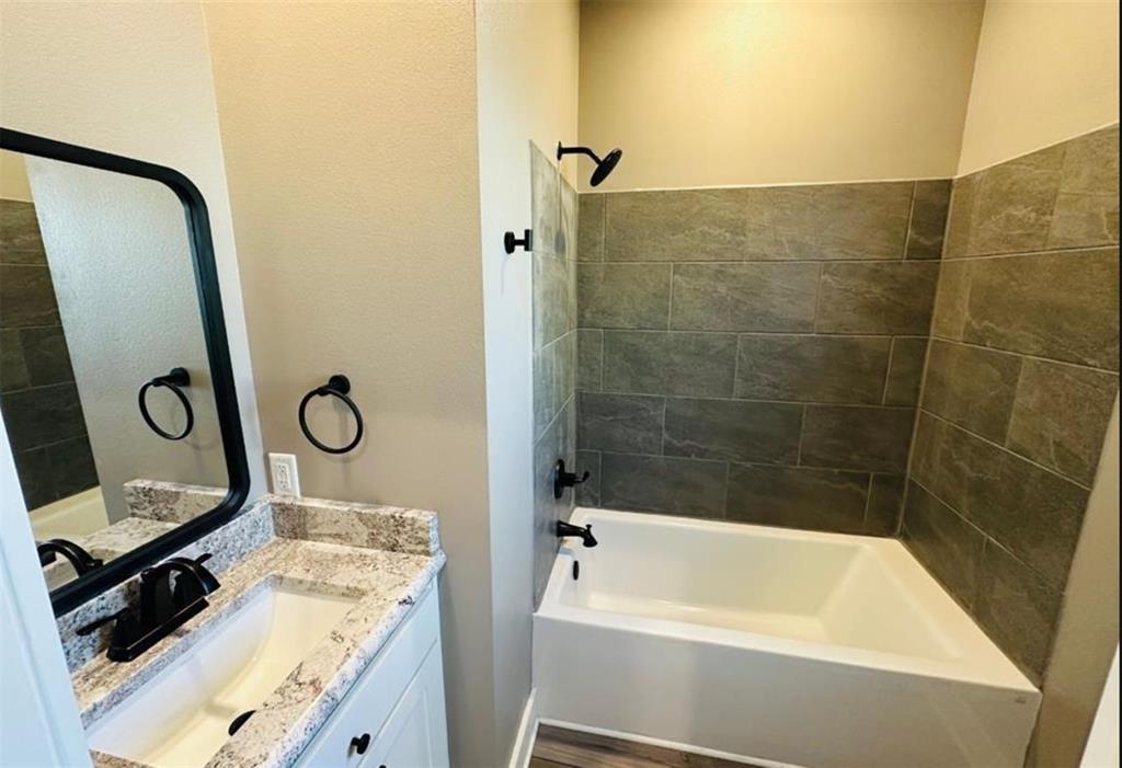 1408 East Houston Street Tyler, TX 75702 - Photo 7 of 15 a bathroom with a tub a sink and a shower