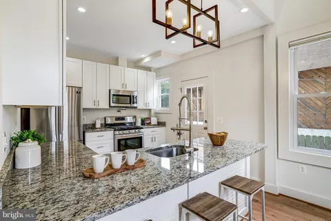 a kitchen with stainless steel appliances granite countertop a stove refrigerator sink and cabinets