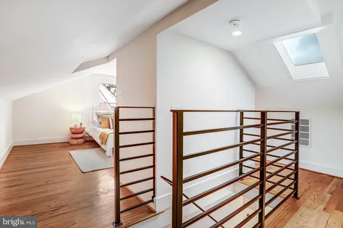 a view of a hallway with wooden floor and staircase