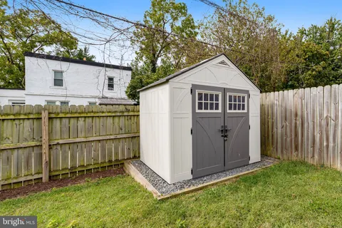 a view of backyard with wooden fence and large trees