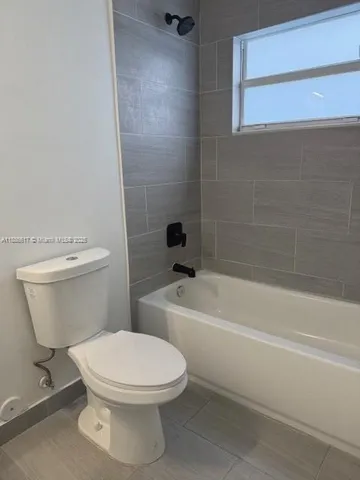 a white toilet and tub sitting next to a bathroom sink