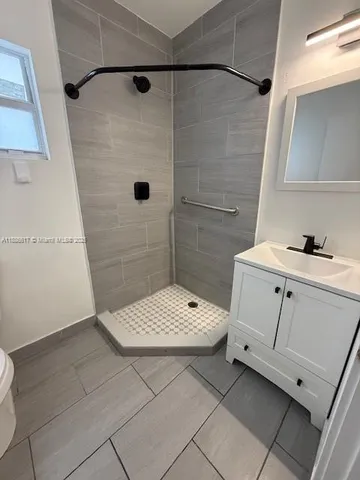 a bathroom with a granite countertop sink a toilet and shower