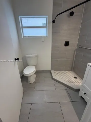 a bathroom with a toilet and a shower