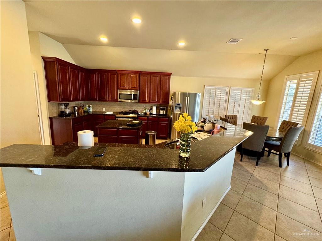 2911 San Rafael Street Mission, TX 78572 - Photo 12 of 38 a kitchen with a stove a sink a dining table and chairs