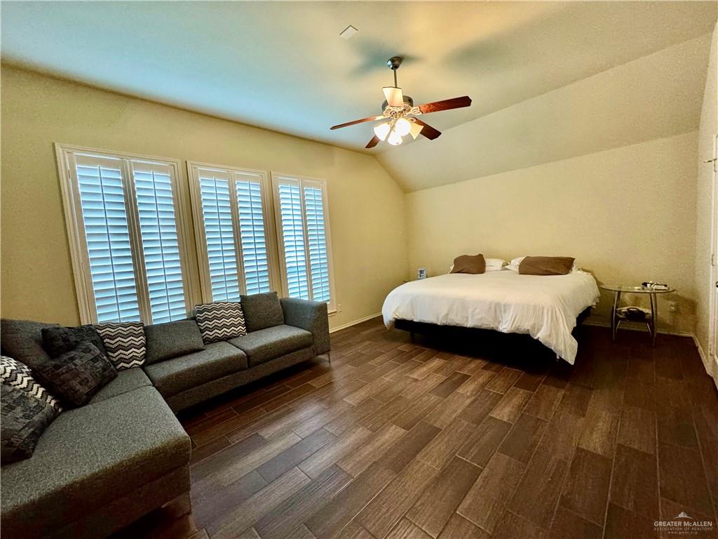 2911 San Rafael Street Mission, TX 78572 - Photo 17 of 38 a spacious bedroom with a bed a couch and a chandelier