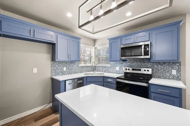 a kitchen with stainless steel appliances a stove microwave and sink