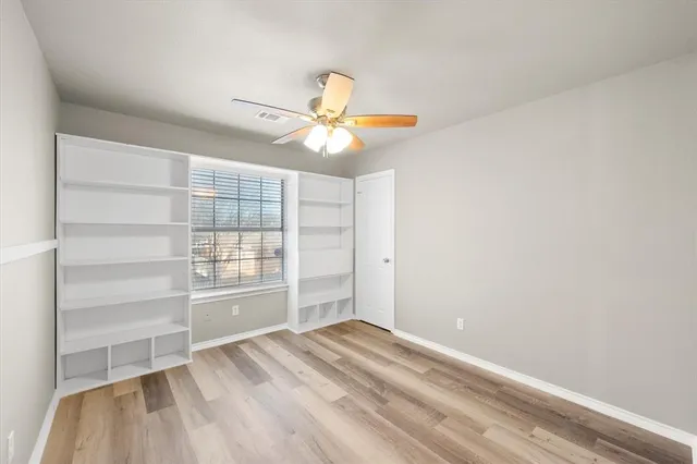 a view of empty room with cabinet and ceiling fan