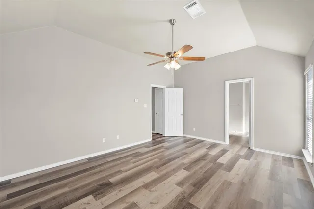 wooden floor in an empty room with a chandelier fan