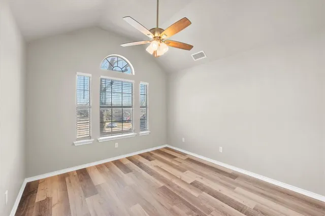 an empty room with windows and fan