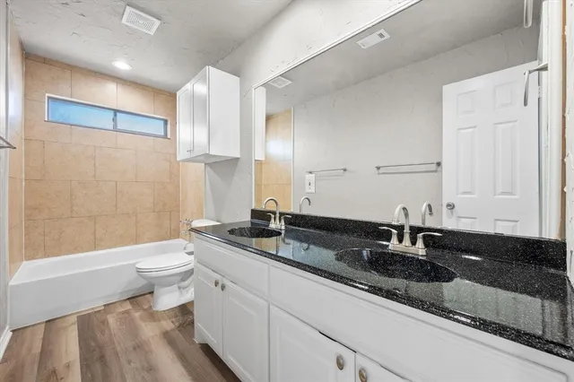 a bathroom with a double vanity sink toilet and shower