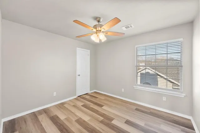 a view of a room with a ceiling fan and a window