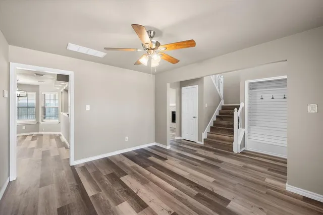 a view of a room with wooden floor and ceiling fan