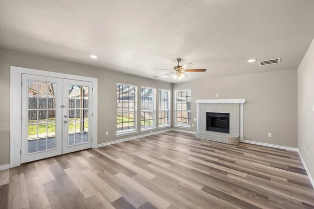 a view of empty room with wooden floor and fireplace