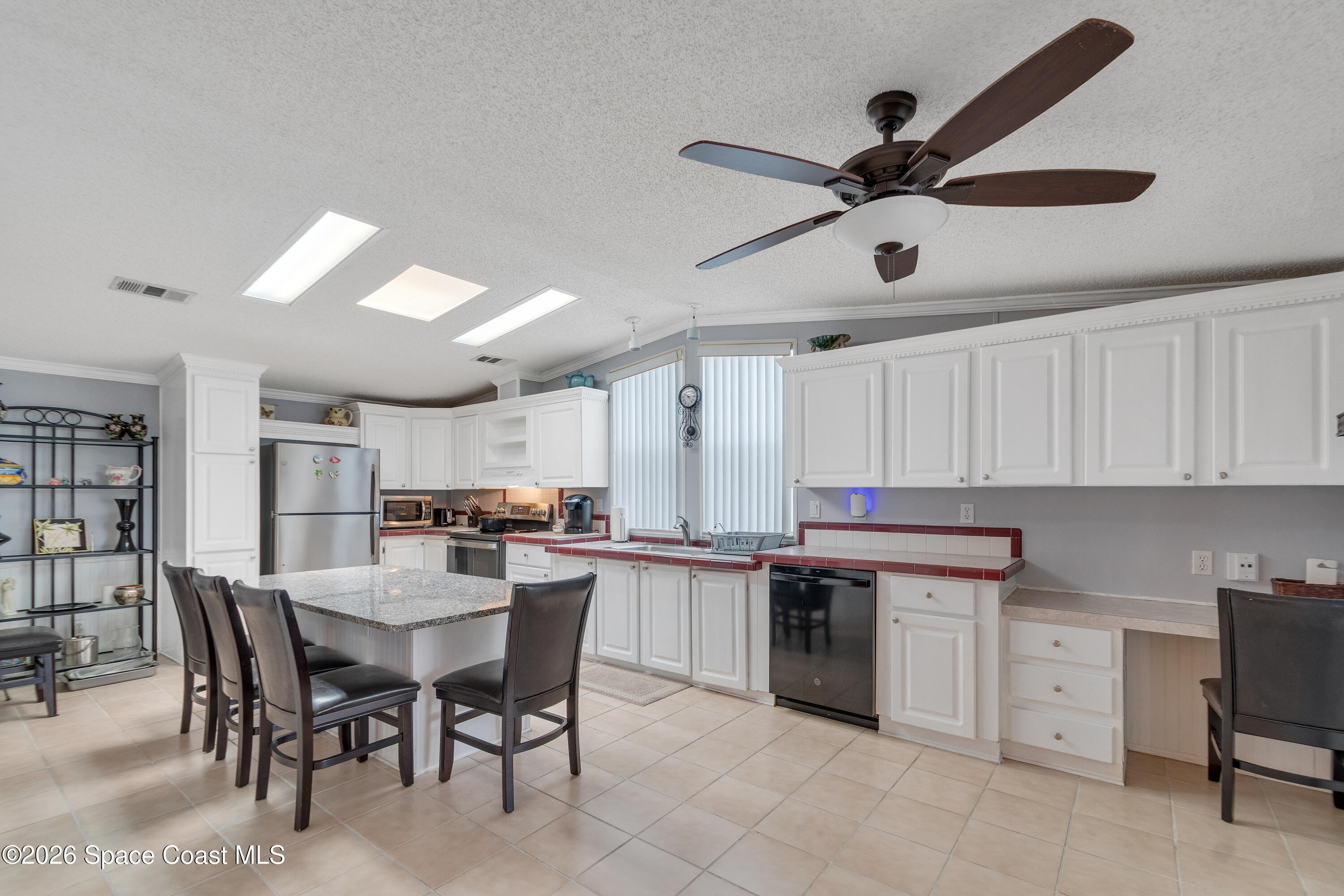 7669 Chasta Road Micco, FL 32976 - Photo 12 of 34 a kitchen with kitchen island a stove a table and chairs in it