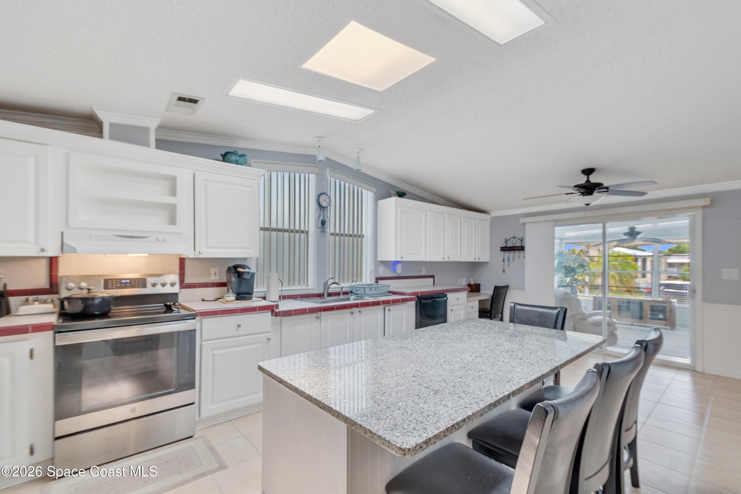 7669 Chasta Road Micco, FL 32976 - Photo 14 of 34 a kitchen with appliances cabinets and wooden floor