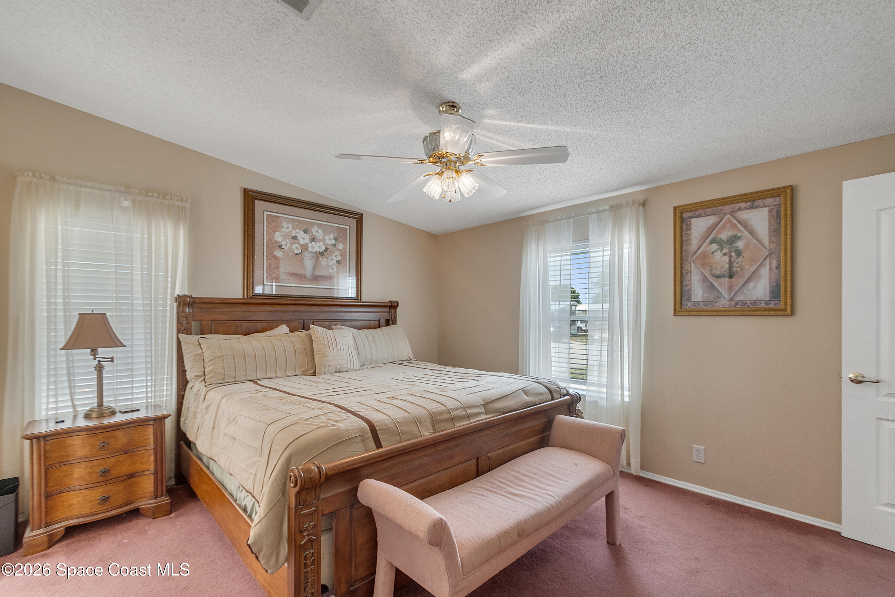 7669 Chasta Road Micco, FL 32976 - Photo 19 of 34 a bedroom with a bed and a chandelier