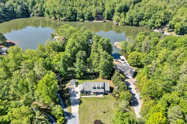 an aerial view of a house with a yard and lake view