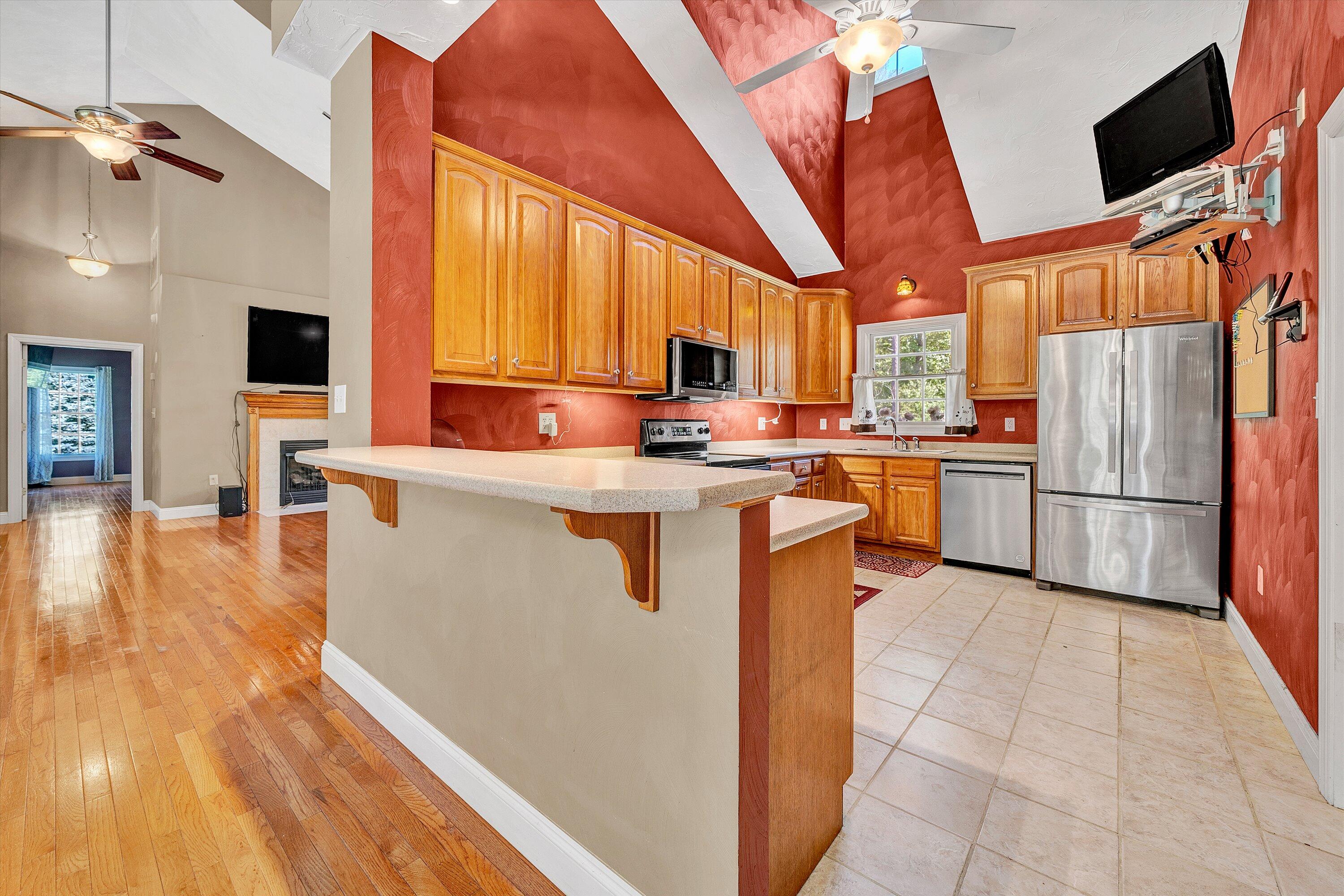 1805 Carroll Road Goodview, VA 24095 - Photo 19 of 61 a kitchen with stainless steel appliances granite countertop a stove top oven a refrigerator a sink and dishwasher with wooden floor