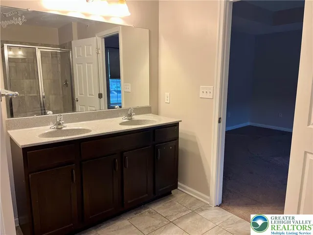 a bathroom with a double vanity sink and a mirror