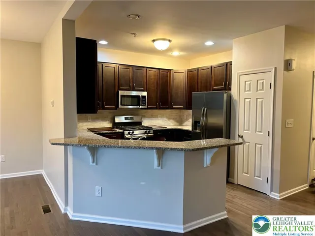 a kitchen with kitchen island a counter top space cabinets and stainless steel appliances