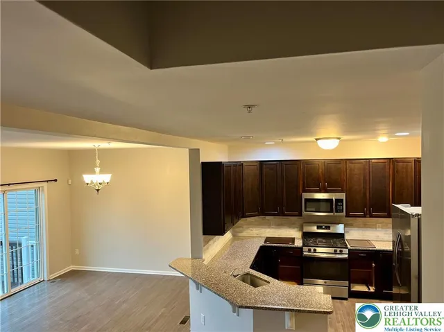 a kitchen with kitchen island a sink and a stove