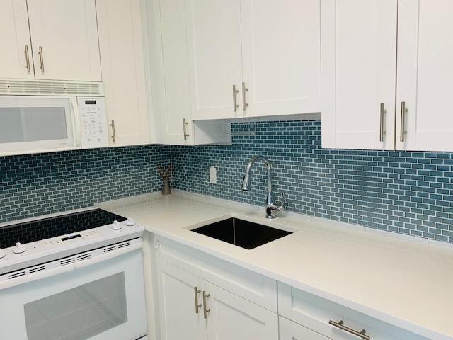 a kitchen with a sink and white cabinets