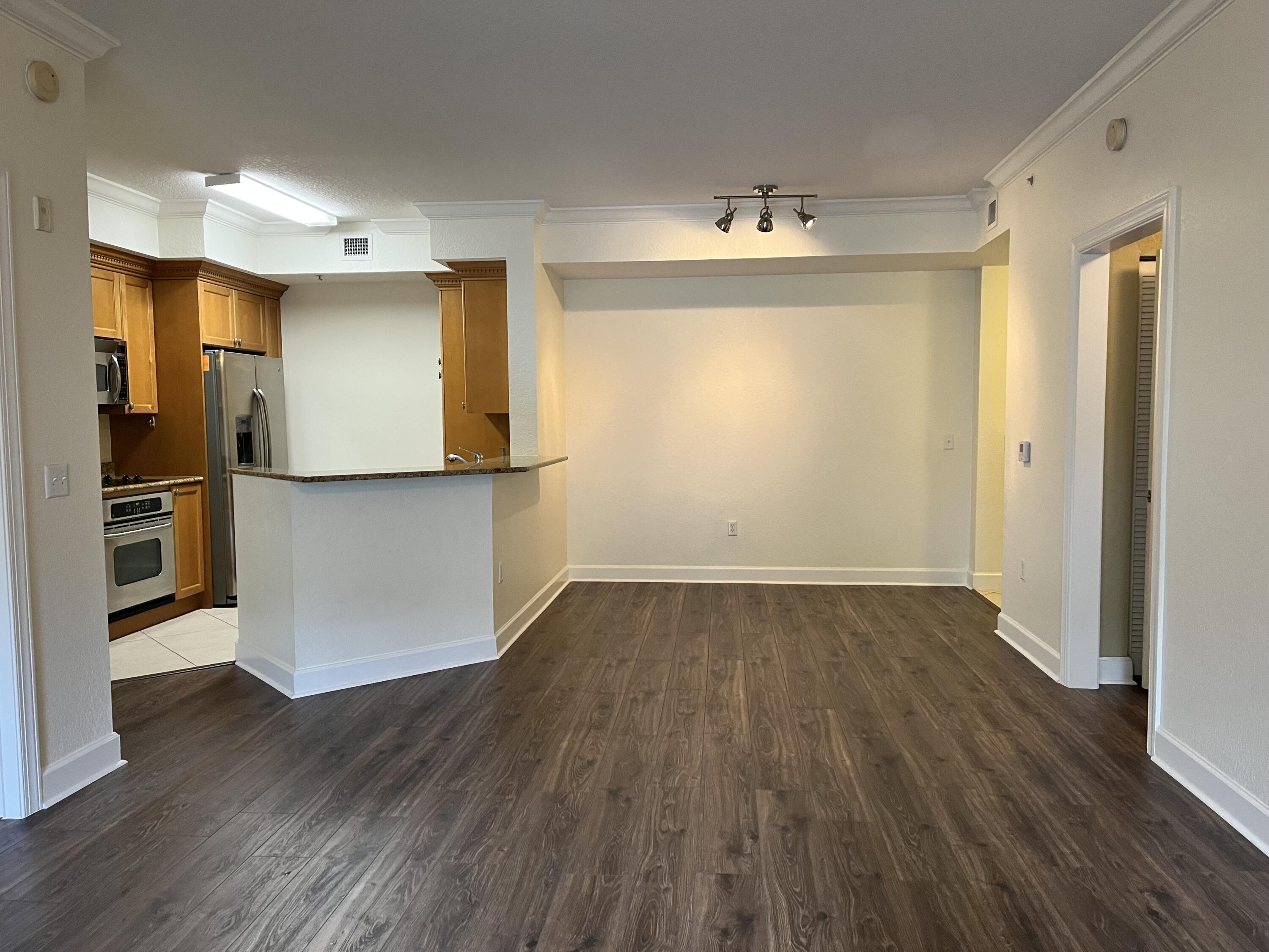 1203 Renaissance Way Boynton Beach, FL 33426 - Photo 2 of 24 an empty room with wooden floor and kitchen view