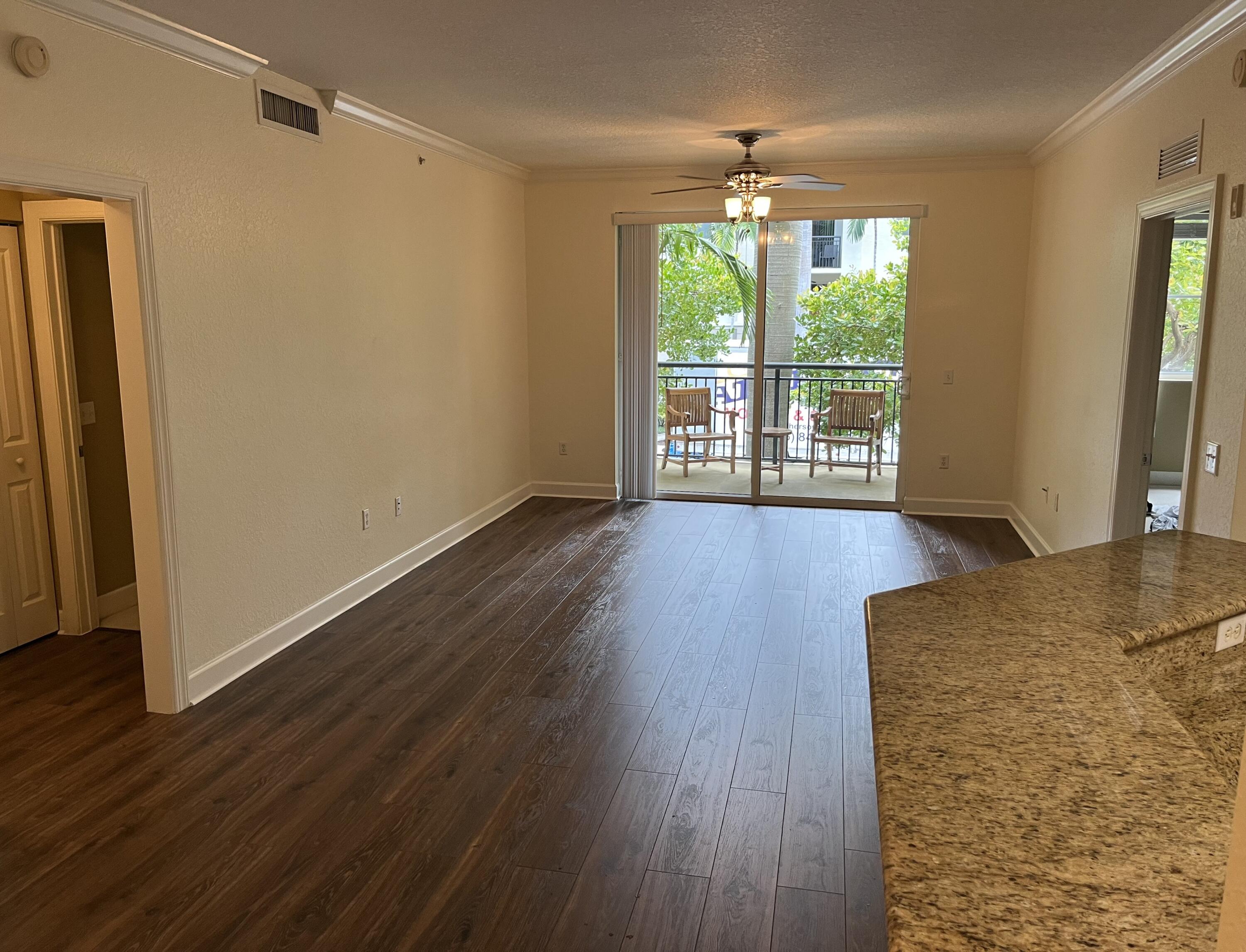 1203 Renaissance Way Boynton Beach, FL 33426 - Photo 4 of 24 a view of an empty room with wooden floor and a window