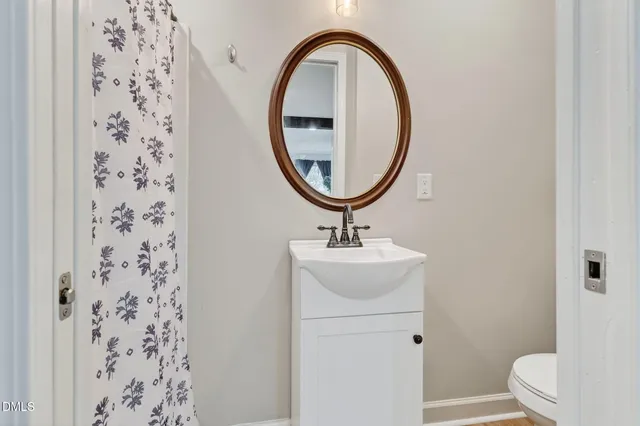 a bathroom with a sink a toilet and a mirror