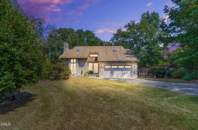 a view of a house with a yard and tree s