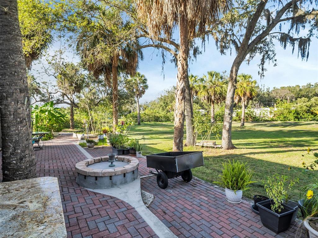 4915 S Road New Port Richey, FL 34652 - Photo 62 of 93 a view of a patio with lawn chairs and a fire pit