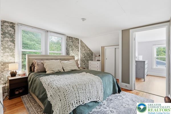 2021 Leithsville Road Hellertown, PA 18055 - Photo 21 of 39 Hardwood floors and a patterned accent wall create a welcoming Primary bedroom retreat.