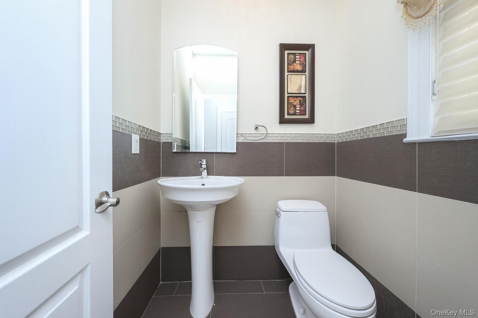 104 Highland Road Staten Island, NY 10308 - Photo 11 of 46 Half bathroom featuring tile walls and wainscoting