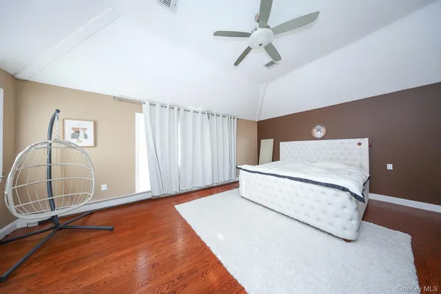 a spacious bedroom with a bed and a chandelier