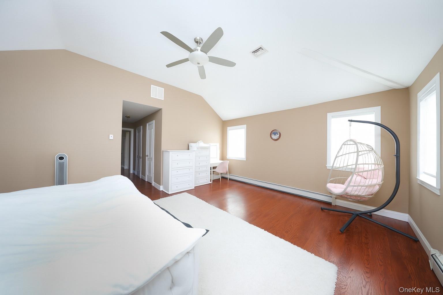 104 Highland Road Staten Island, NY 10308 - Photo 8 of 46 Bedroom with vaulted ceiling, dark wood-style flooring, a baseboard heating unit, and a ceiling fan