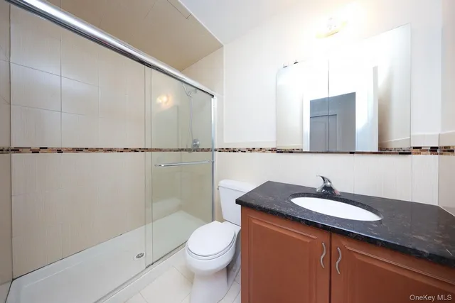 a bathroom with a sink a toilet a mirror and shower