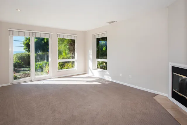 a view of an empty room with a sliding door and balcony view