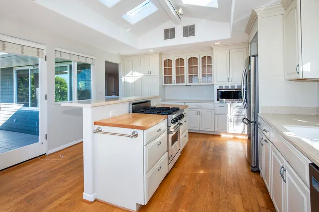 a kitchen that has a stove and a wooden floor