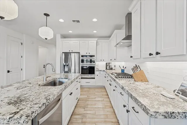 a large kitchen with kitchen island granite countertop a large counter top and stainless steel appliances