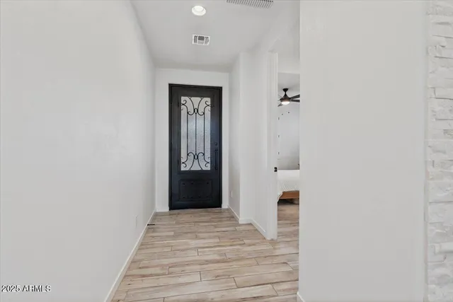 a view of a hallway with wooden floor and staircase