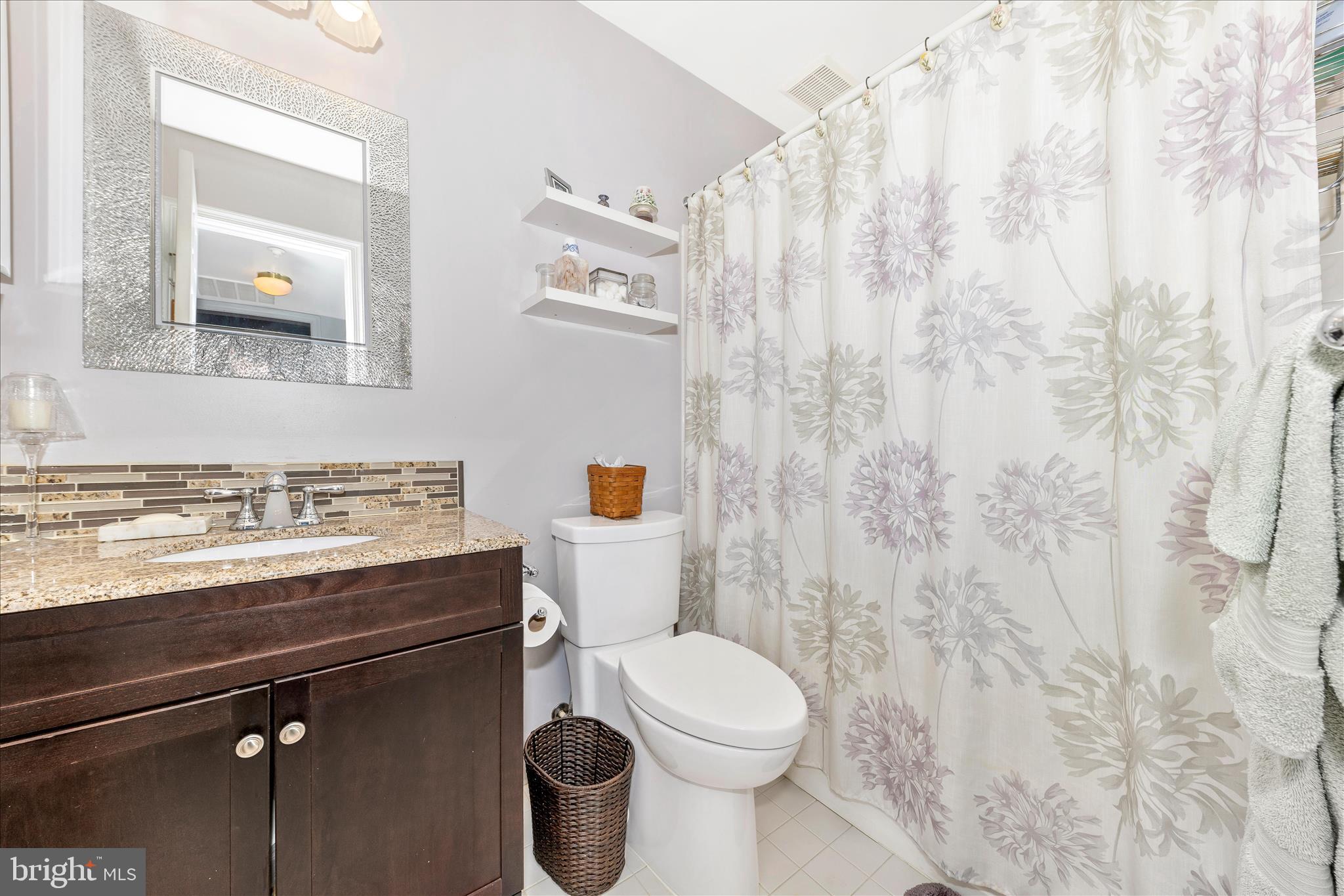 2205 Garden Lane Frederick, MD 21701 - Photo 28 of 48 a bathroom with a granite countertop sink a toilet and a mirror