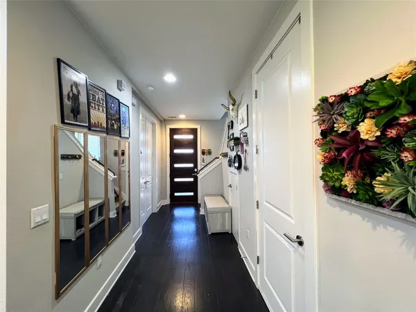 a view of a hallway with wooden floor and stairs
